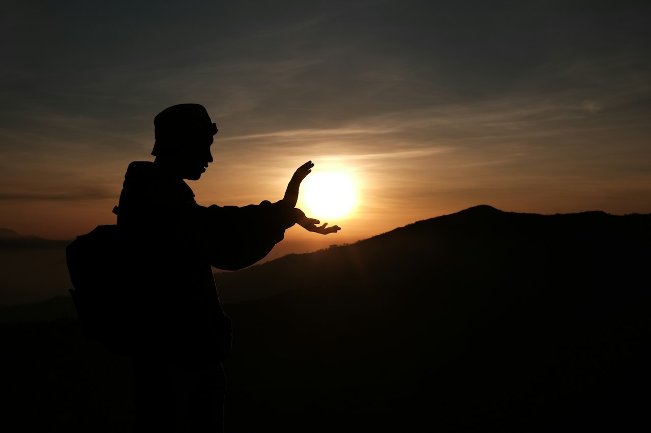 Silhouette bei Qi-Gong-Übung vor der Sonne